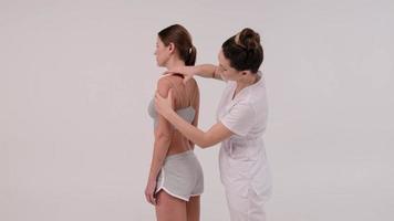 le thérapeute applique du ruban kinesio sur le corps de la femme. concepts de physiothérapie et de kinésiologie.