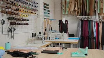atelier de tailleur studio, confection de vêtements sur commande. intérieur du petit studio de mode. vue des rouleaux de tissu, des bobines de fil et des motifs