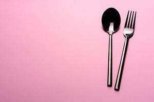 cuillère et fourchette en métal isolé sur fond rose