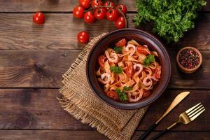 pâtes fettuccine aux crevettes, tomates cerises, sauce, épices et herbes photo