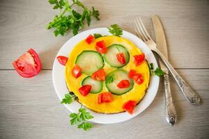 frit omelette avec courgette, tomates, herbes dans une assiette photo