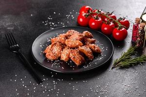 filet de poulet aux graines de sésame, sauce teriyaki sur plaque de pierre noire photo