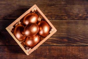 oeufs de pâques dans une boîte en bois cadeau sur fond de bois foncé photo