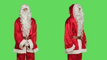 Père Noël claus agissant mécontent dans studio, en disant non plus de écran vert toile de fond. homme portant de fête père Noël costume avec chapeau et barbe, étant déçu et spectacles désaccord. photo