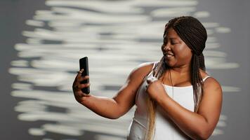 beauté modèle en utilisant téléphone intelligent à prendre des photos sur caméra, La publicité soin de la peau produits de beauté et corps confiance dans studio. sans faille la personne prise Photos dans studio, doux élégant fille.