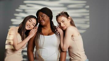 groupe de multiracial femmes souriant pour corps positivité publicité, courbée et maigre copains La publicité la féminité et corps confiance. les filles avec différent les teintes de peau et corps les types dans studio. photo