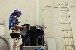 méticuleux câbleur commandé pour à l'extérieur HVAC système annuel entretien, à la recherche pour fréon fuites. qualifié expert Faire air Conditionneur enquête, ajouter Les données sur portable photo