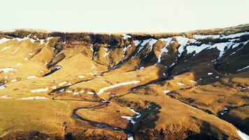 aérien vue de foutre une sidu cascade création fantastique congelé paysage, islandais paysage. magnifique scandinave Cascade fonctionnement vers le bas de de collines, scénique itinéraire. lent mouvement. photo