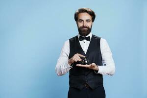 Hôtel la conciergerie détient un service cloche utilisé à bague pour assistance et Aidez-moi à de face bureau. Masculin groom employé dans formel costume en présentant hospitalité industrie, portier porter emploi. photo