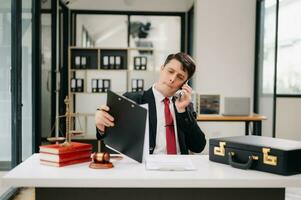 Justice et loi concept. Masculin juge dans une salle d'audience le marteau, travail avec intelligent téléphone et portable et numérique tablette ordinateur sur bois table photo