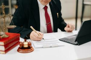 Justice et loi concept. Masculin juge dans une salle d'audience il marteau, travail avec intelligent téléphone et portable et numérique tablette sur blanc table photo