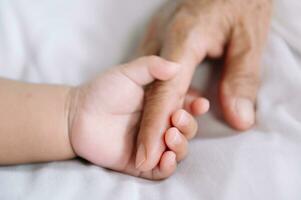mains de le femme et une enfant main sur le blanc lit photo