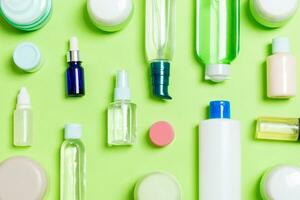 groupe de bouteille de soin du corps en plastique composition à plat avec des produits cosmétiques sur fond vert espace vide pour votre conception. ensemble de contenants cosmétiques blancs, vue de dessus avec espace de copie photo