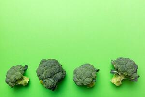 Haut vue Frais vert brocoli légume sur coloré Contexte. brocoli chou tête en bonne santé ou végétarien nourriture concept. plat poser. copie espace photo