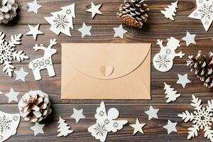 vue de dessus de l'enveloppe sur fond de bois festif. jouets et décorations de Noël. concept de temps du nouvel an photo