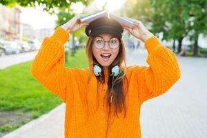 content étudiant fille avec une livre sur sa tête ayant amusement Extérieur après cours. photo