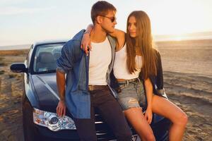 attrayant couple posant près voiture sur le plage. photo