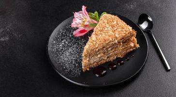 délicieux gâteau napoléon frais avec de la crème sur un fond sombre photo