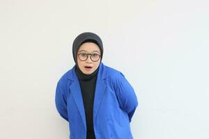 magnifique Jeune asiatique musulman femme, portant des lunettes et bleu blazer avec sous le choc expression photo
