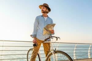 Jeune attrayant homme en voyageant sur vélo par mer photo