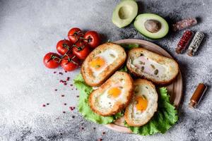 délicieux petit déjeuner avec grognements, œufs, avocat et tomates cerises photo