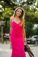 élégant attrayant femme portant rose sexy été robe en marchant dans rue photo