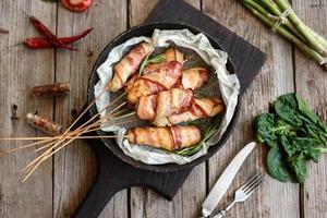 rouleau avec bacon et poulet haché sur un ragoût d'asperges fraîches photo