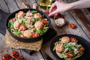 délicieuses pâtes fraîches aux boulettes de viande, sauce, tomates cerises et basilic photo