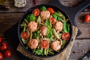 délicieuses pâtes fraîches aux boulettes de viande, sauce, tomates cerises et basilic photo