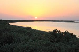 beau coucher de soleil orange sur une plage tropicale. photo