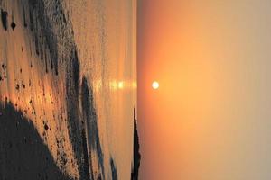 beau coucher de soleil orange sur une plage tropicale. photo