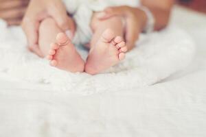 pieds de bébé nouveau-né dans les mains de la mère. photo