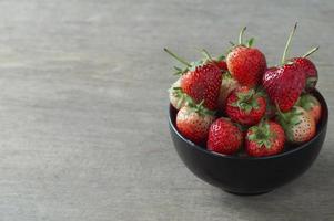 fraises fraîches dans un bol sur une table en bois et espace de copie
