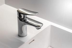 nouveau robinet en acier inoxydable sur un évier de lavabo propre dans la salle de bain
