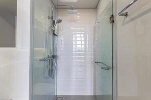 douche en gros plan et porte vitrée dans la salle de bain, salle de carrelage blanc photo