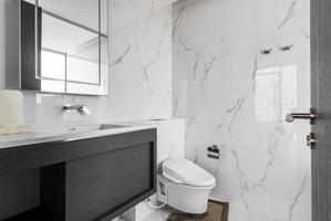 salle de bain moderne et bois blanc avec cabine de douche en verre dans l'appartement photo