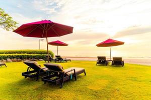 parapluie avec chaise avec fond de plage de mer et lever de soleil le matin