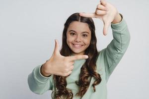 fille souriante et positive posant sur un fond de mur blanc photo