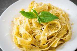 pâtes fettuccine au pesto avec du parmesan sur le dessus - style cuisine italienne photo