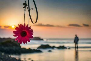 une rose fleur est pendaison de une crochet sur le plage à le coucher du soleil. généré par ai photo