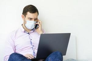 un homme en chemise et jean résout les problèmes de travail à distance. photo