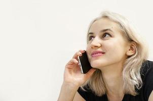 une jeune fille aux cheveux blonds communique au téléphone. photo