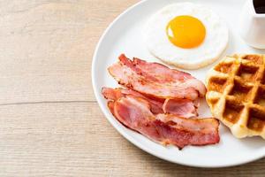 oeuf au plat avec bacon et gaufre pour le petit déjeuner photo