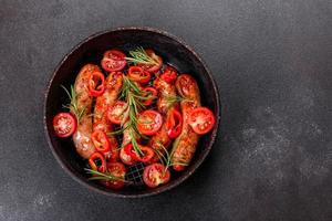 saucisses grillées aux légumes et épices sur fond noir photo