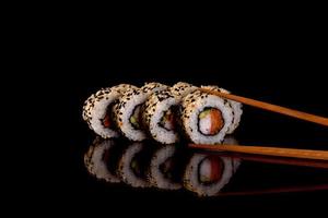 De délicieux rouleaux de sushi frais sur fond sombre photo