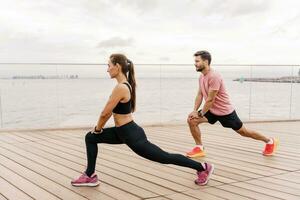 instructeurs sont une femme et une homme dans aptitude fonctionnement vêtements. gens faire des exercices formateurs utilisation aptitude regarder et app pour exercice résultats. physique éducation ensemble, famille couple en bonne santé mode de vie. photo