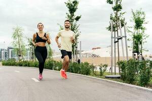 une fonctionnement instructeur et une client sont formation aptitude en plein air. une femme et une homme sont copains dans aptitude vêtements pour des sports. gens utilisation aptitude montres et fonctionnement chaussures. photo