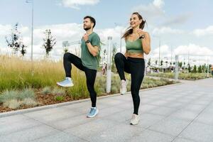 les athlètes sont copains de fonctionnement des exercices. coureurs sont une Jeune couple formation sur le rue. une aptitude instructeur et une femme formation dans tenue de sport et baskets. photo