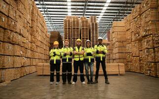 portrait de une groupe de ouvriers travail dans une travail du bois usine, permanent avec bras franchi dans une en bois entrepôt. photo