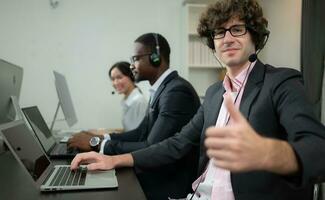 groupe de affaires gens portant casque travail activement dans bureau. appel centre, télémarketing, client soutien agent fournir un service sur Téléphone vidéo conférence appel. photo